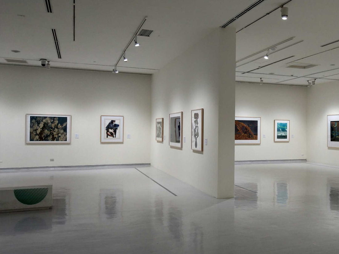 A pale minimal gallery corridor with works hung at intervals